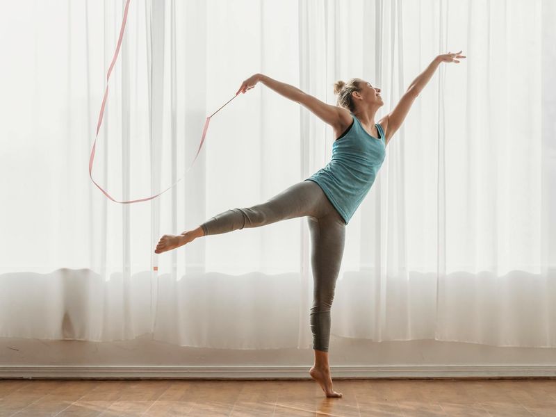 Athletic person doing rhythmic movements with high contrast shadows.