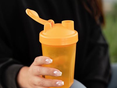 Hands holding a water bottle after a workout.